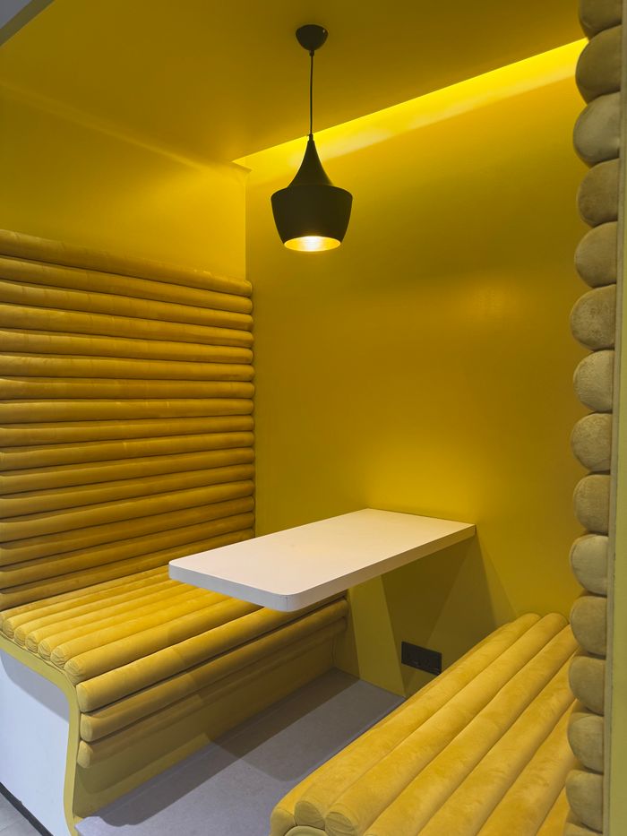 Crafting Captivating Headlines: Your awesome post title goes here A stylish yellow seating booth with a pendant light in a Dhaka cafe, perfect for modern interiors.